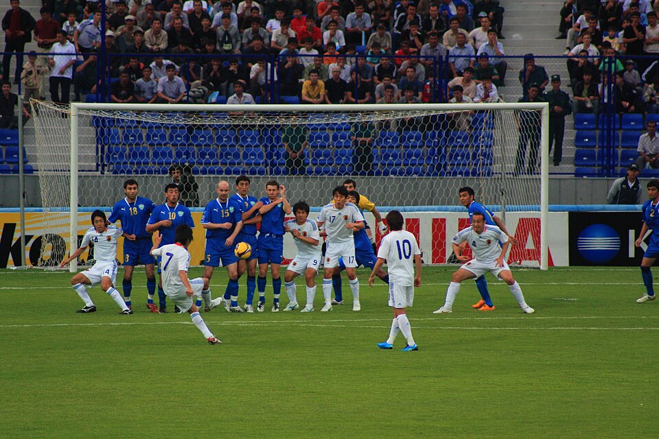 Barrera defensiva en un partido de fútbol nocturno